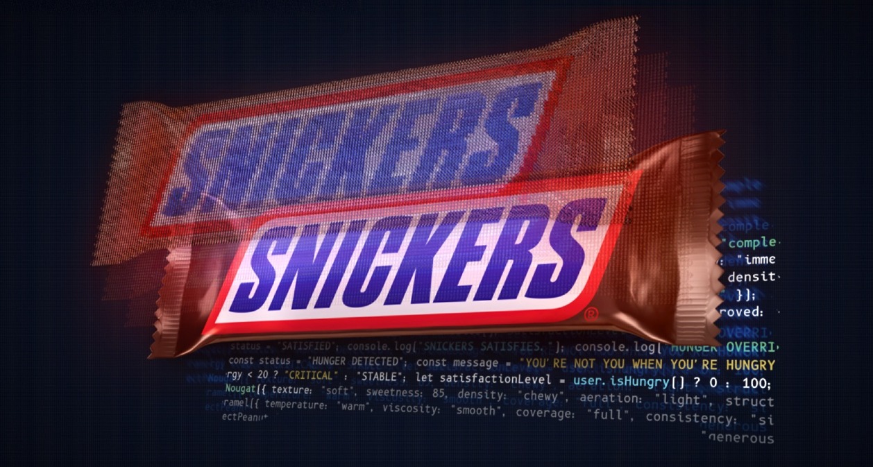 Una barra de chocolatina Snickers sobre un fondo de código de programación
