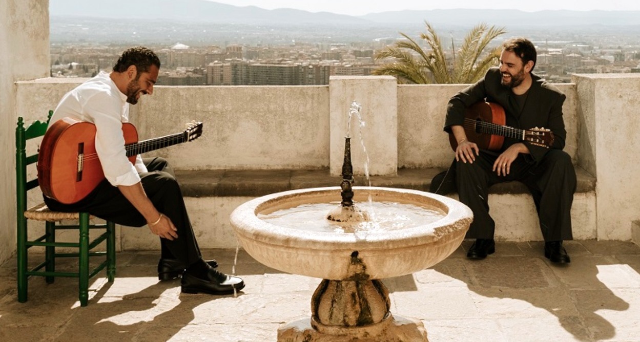 Dos hombres en una terraza con sus guitarras flamencas
