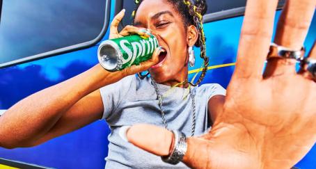 Chica bebiendo de una lata de Sprite