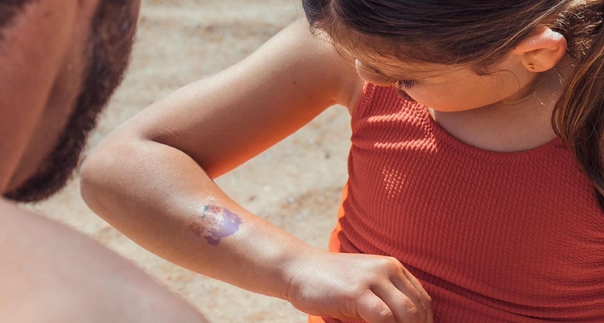 una niña mirándose el brazo con la calcomanía