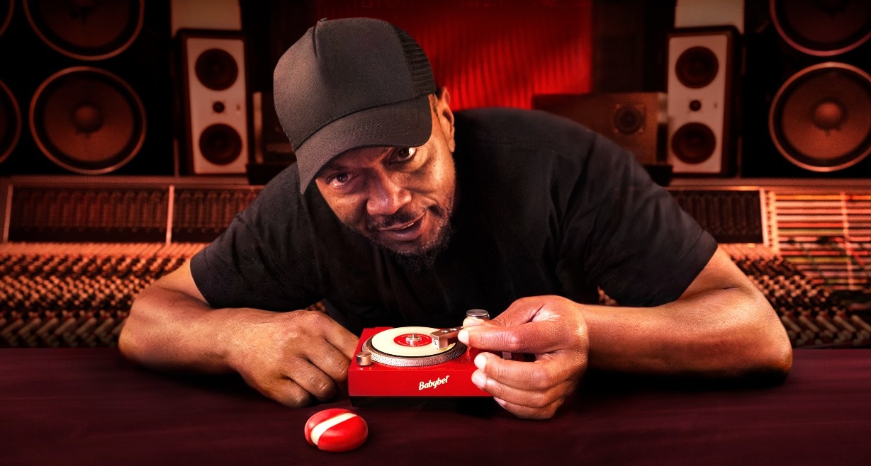 Timbaland posando junto al tocadiscos mini de babybel