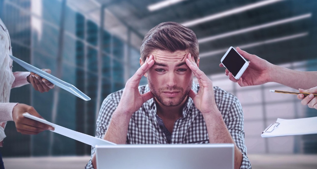 Un chico estresado rodeados de manos que le piden que haga tareas de trabajo