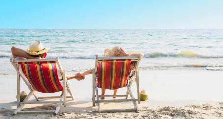 Dos personas sentadas en hamacas en la orilla del mar