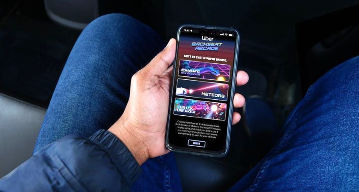 Un viajero sosteniendo el smartphone con la interfaz del juego de arcade