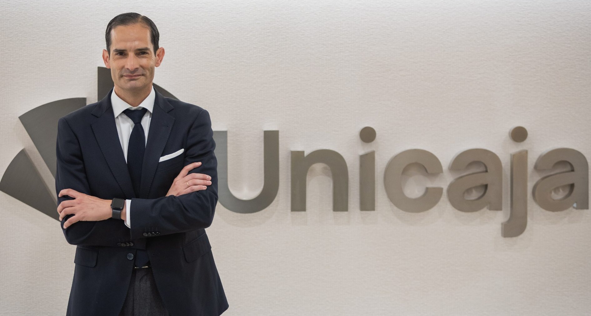 Gonzalo Saiz ante el logo de Unicaja