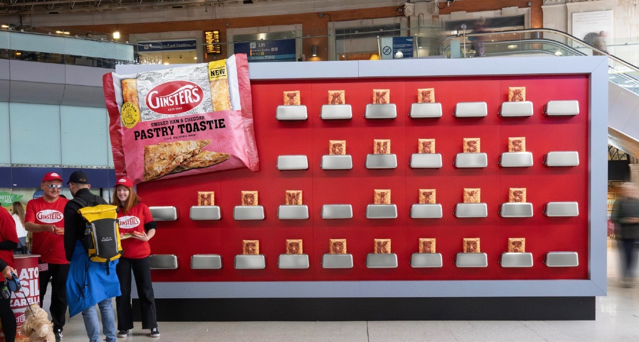 Una valla de publicidad con fondo rojo y decenas de tostadoras colocadas encima