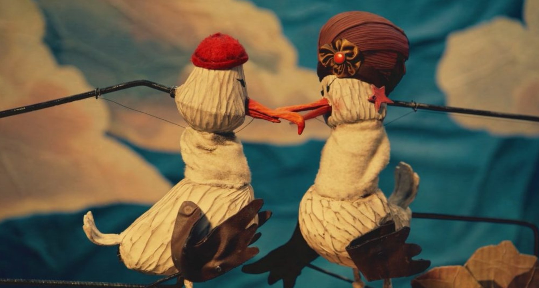 Dos albatros creados con marionetas mirándose entre sí antes de separarse.