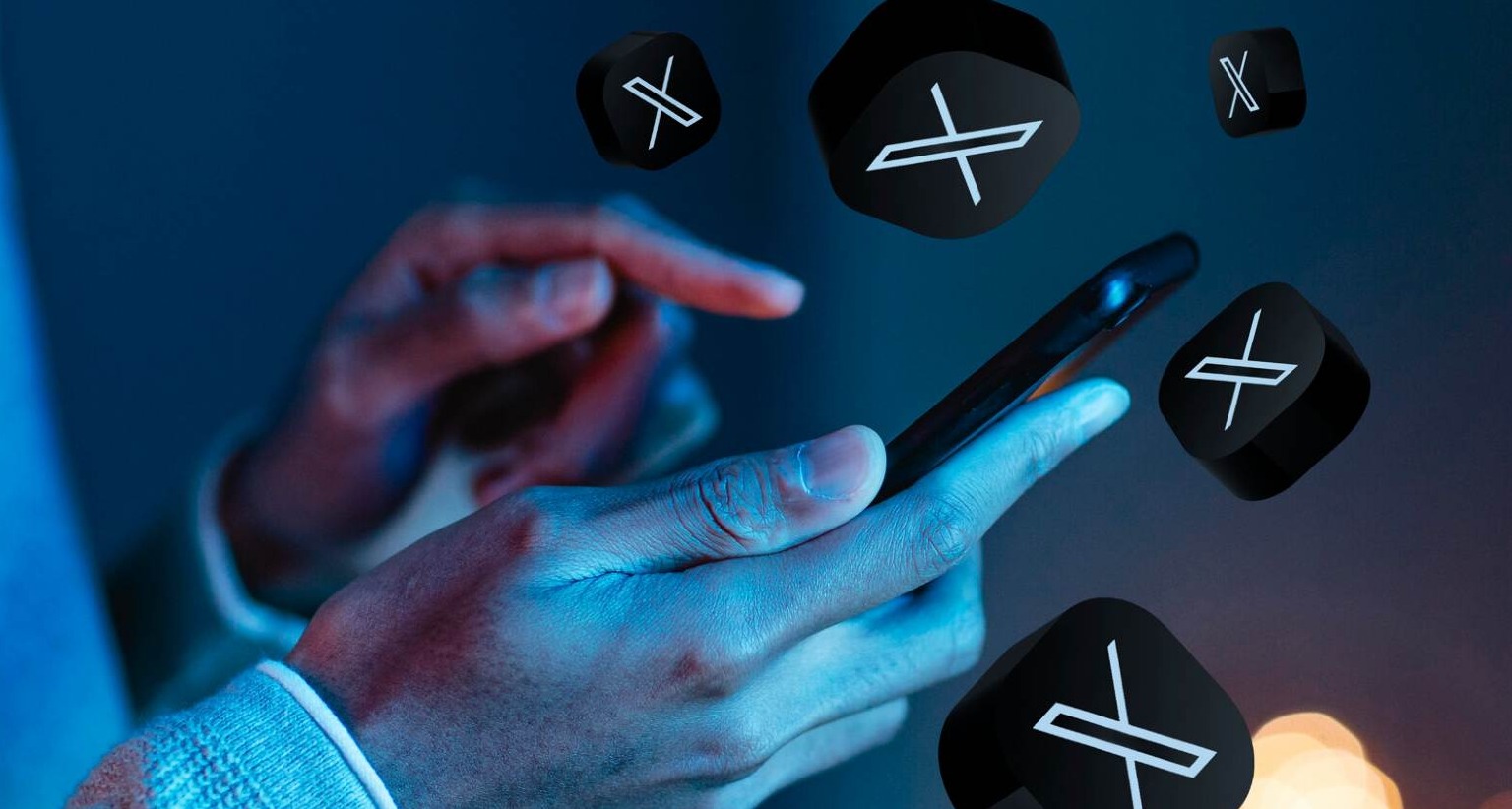 Manos de hombre sujetando un móvil con iconos de X alrededor