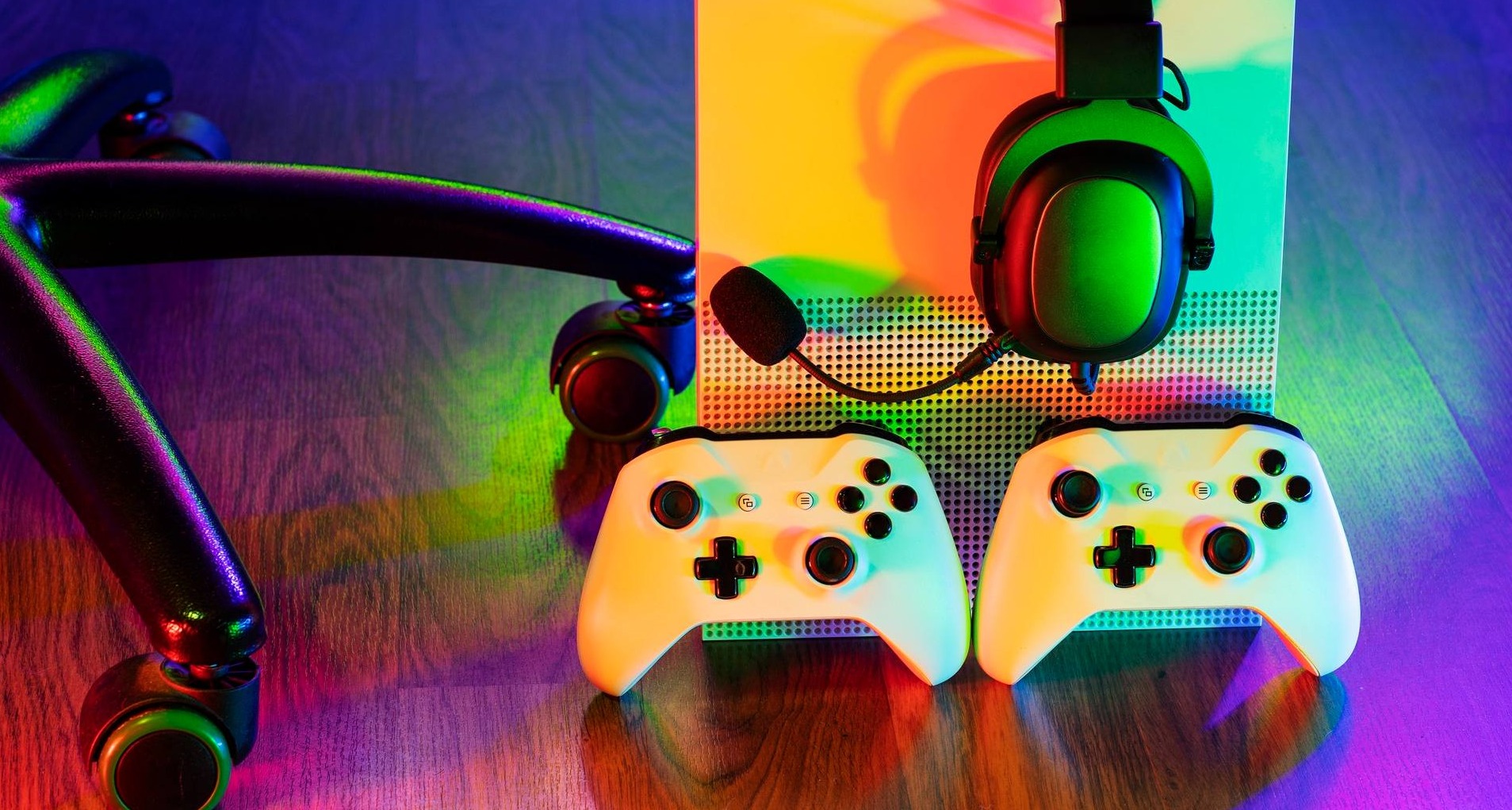Dos mandos de Xbox en el suelo junto a la videoconsola
