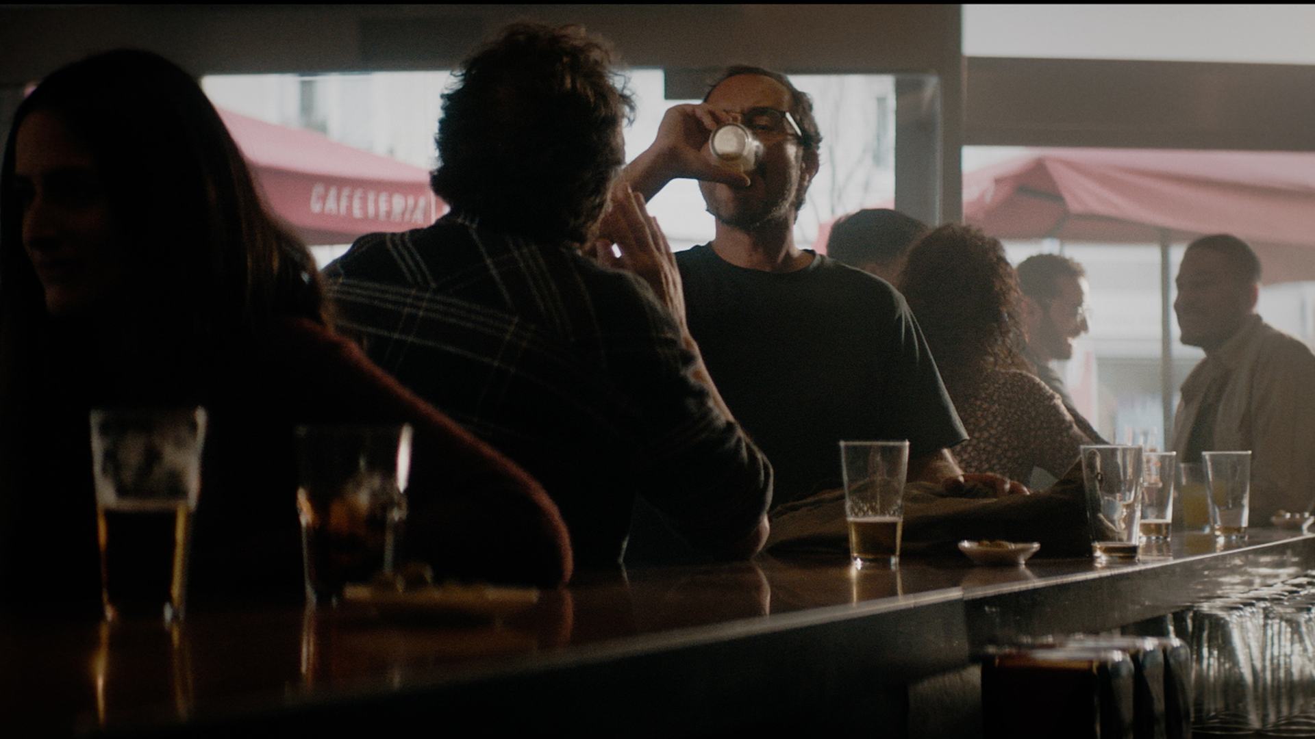 Un hombre bece cerveza en un bar en una imagen del spot
