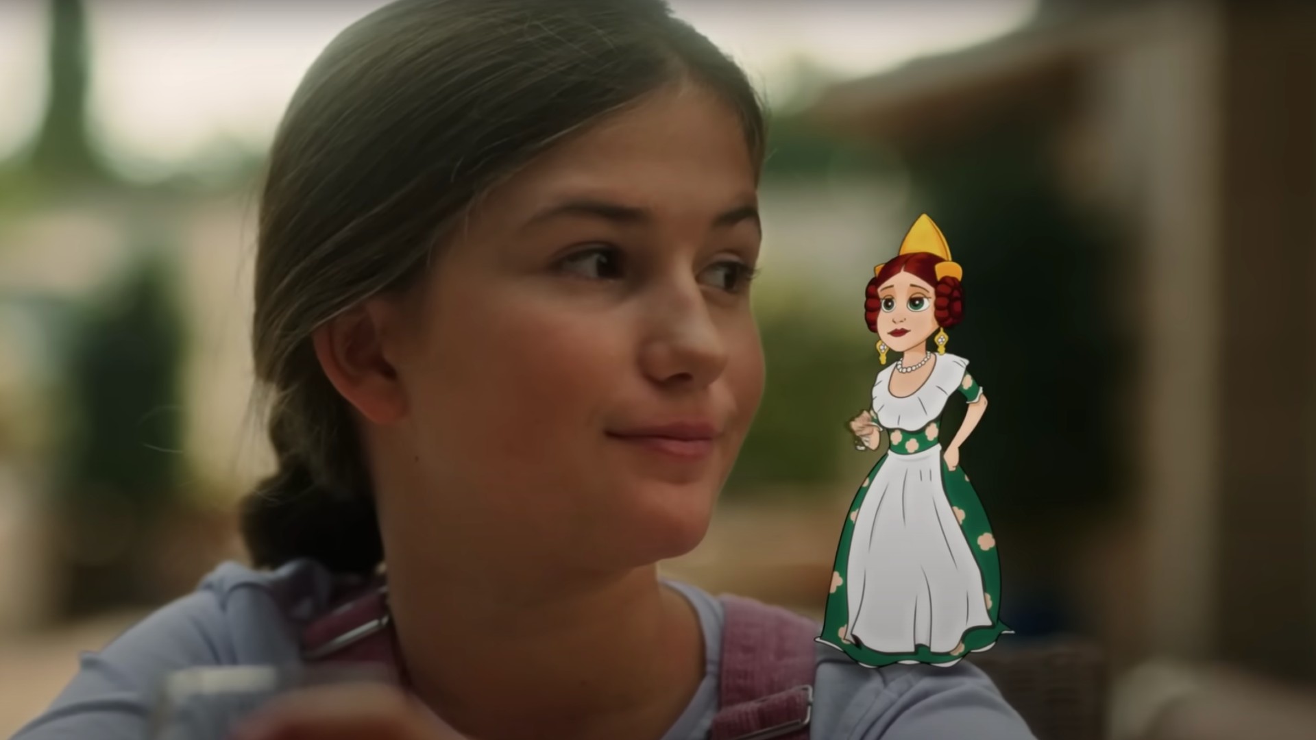 Una niña mira a un personaje de animación de pie sobre su hombro que representa a una mujer con el traje típico valenciano.