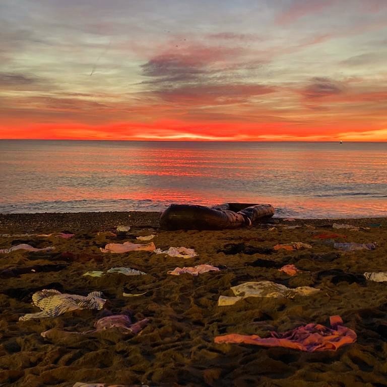 Imagen de la playa de Barcelona al amanecer con la ropa tendida en la arena.