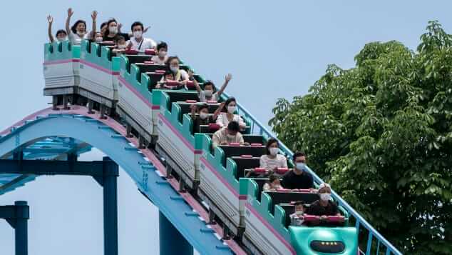 usuarios de montaña rusa con mascarillas en parque de atracciones