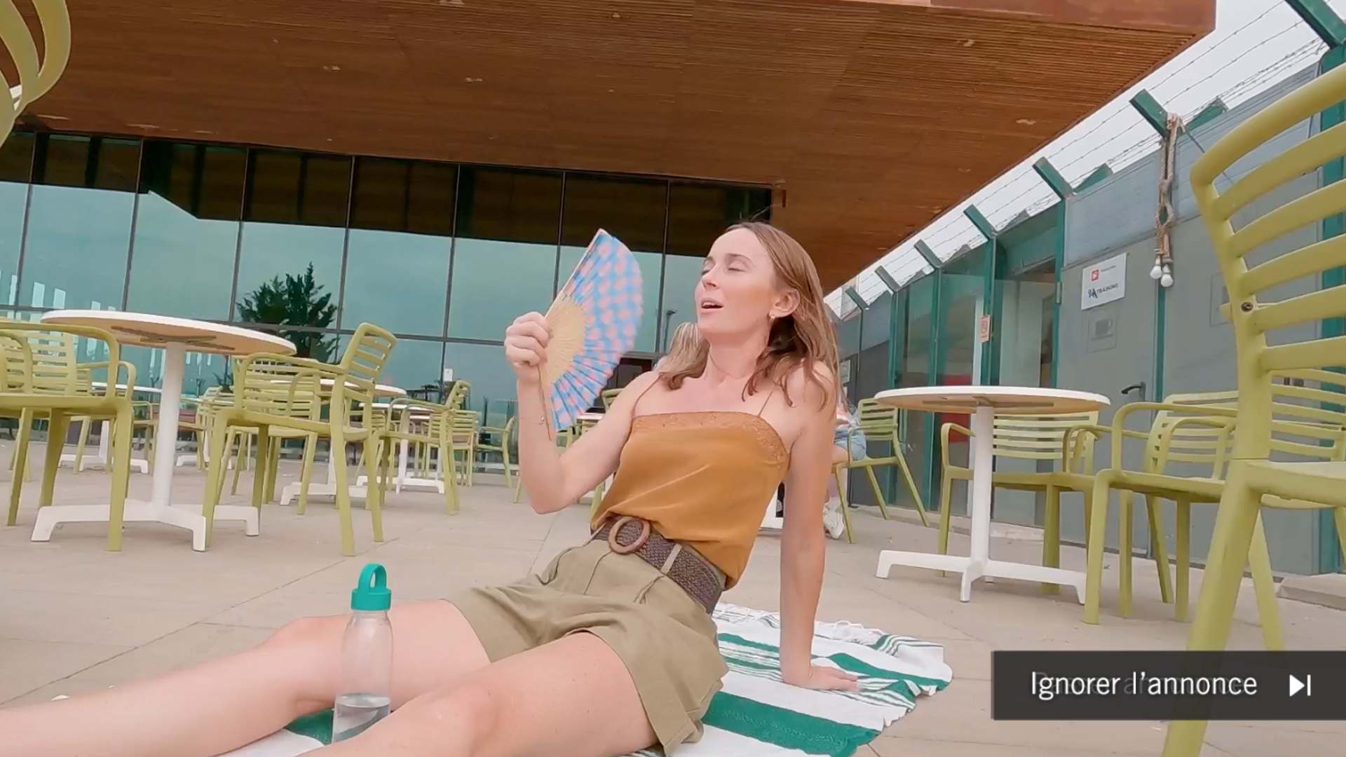 Chica abanicándose en sala de espera de aeropuerto